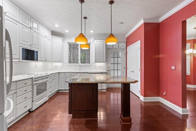 kitchen featuring white cabinetry, white appliances, pendant lighting, and a kitchen island