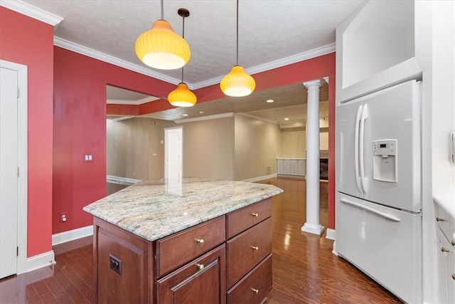 kitchen featuring crown molding, decorative light fixtures, white refrigerator with ice dispenser, and ornate columns