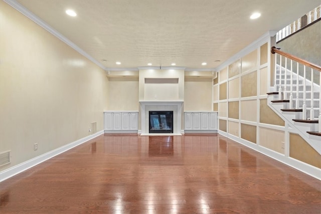 unfurnished living room with ornamental molding and hardwood / wood-style floors