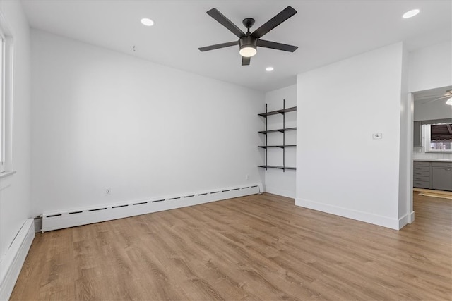 empty room featuring baseboard heating, light wood-type flooring, and ceiling fan