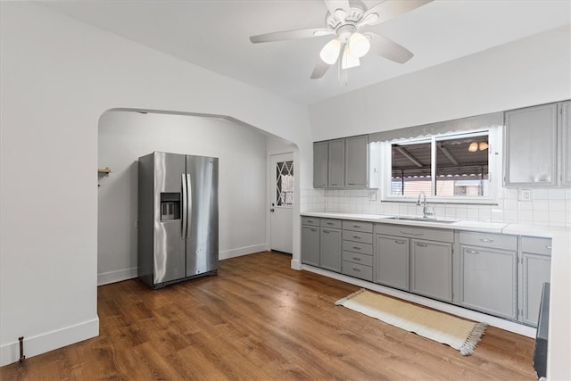 kitchen featuring dark hardwood / wood-style floors, gray cabinetry, sink, stainless steel fridge with ice dispenser, and ceiling fan