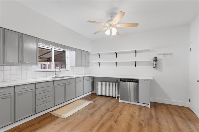 kitchen with gray cabinets, sink, radiator, and light wood-type flooring