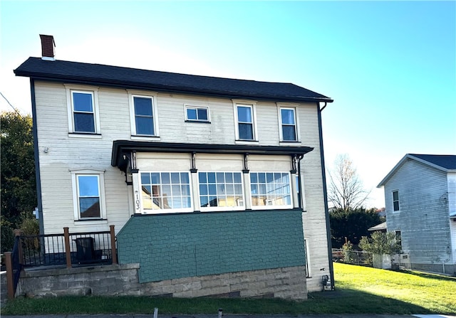 rear view of property with a yard