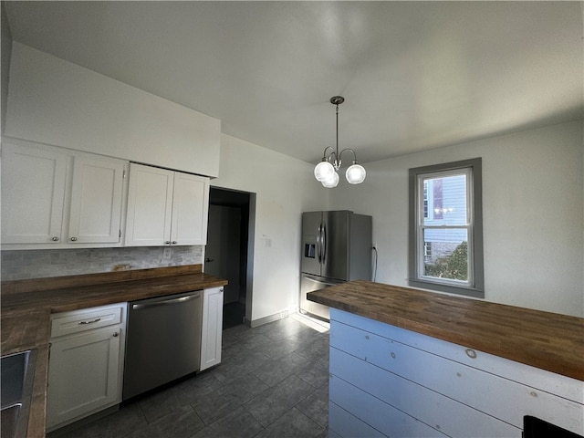 kitchen with white cabinetry, wooden counters, stainless steel appliances, and hanging light fixtures