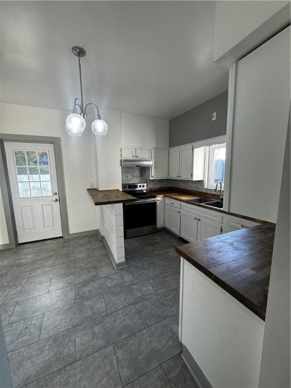 kitchen featuring sink, stainless steel range with electric stovetop, kitchen peninsula, white cabinetry, and pendant lighting