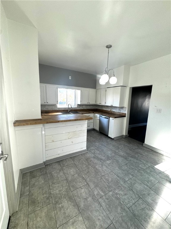 kitchen featuring white cabinetry, wood counters, dishwasher, and decorative light fixtures