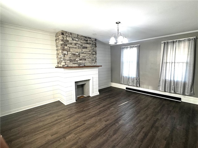 unfurnished living room with ornamental molding, an inviting chandelier, dark hardwood / wood-style floors, and a fireplace