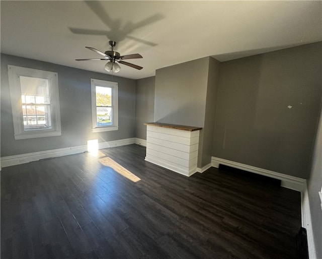 empty room featuring ceiling fan and dark hardwood / wood-style flooring