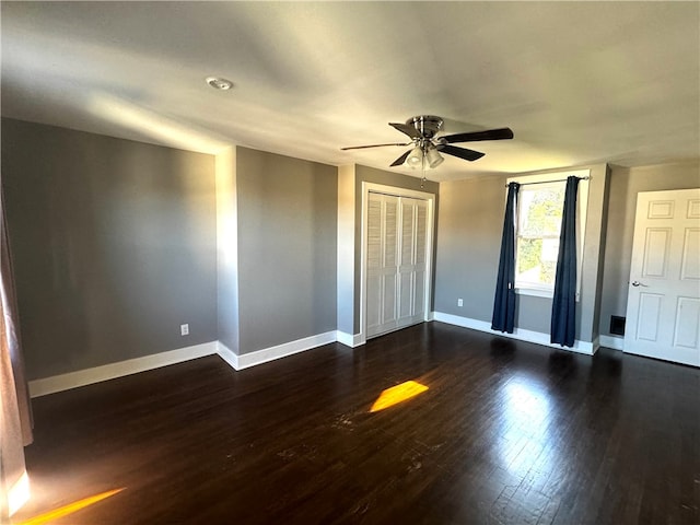 unfurnished bedroom featuring a closet, ceiling fan, and dark hardwood / wood-style floors