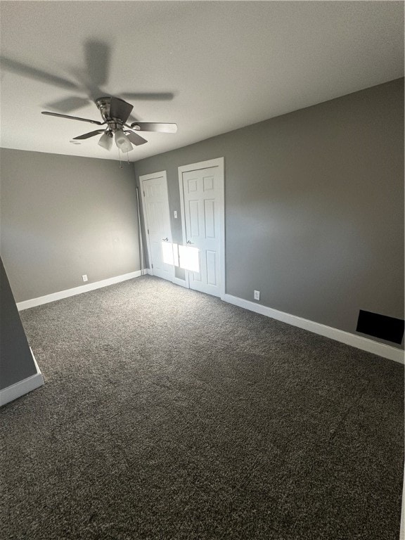 unfurnished bedroom with ceiling fan and dark carpet