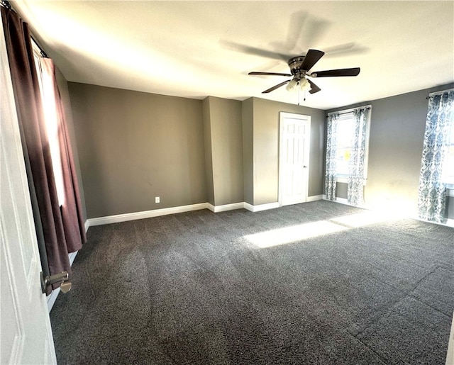 unfurnished bedroom with dark colored carpet and ceiling fan