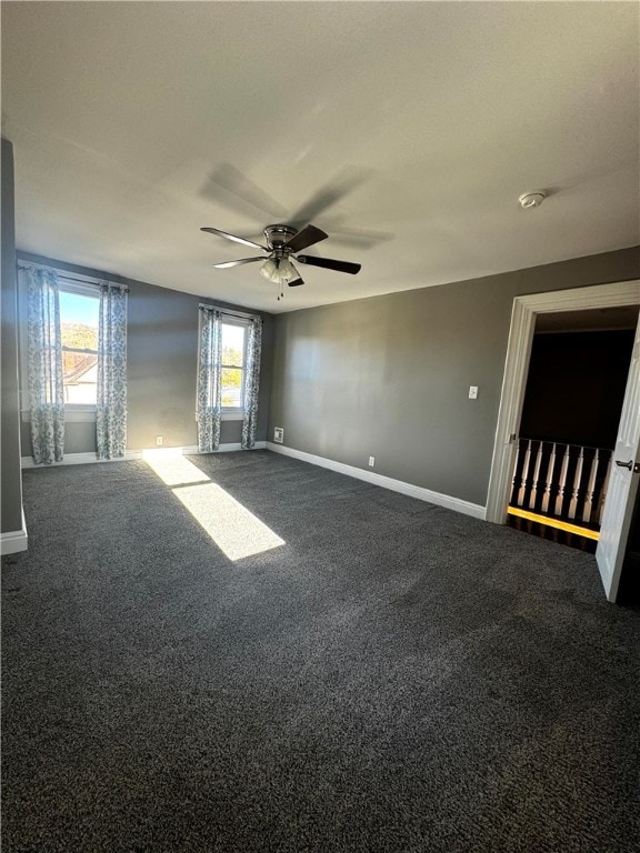 carpeted spare room featuring ceiling fan