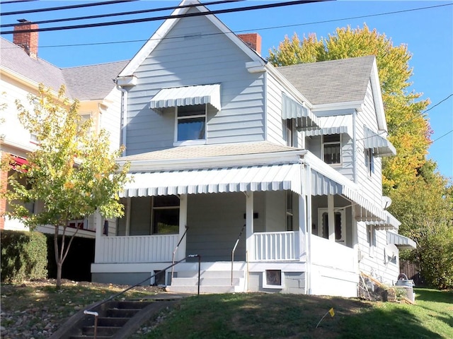 view of front of house featuring covered porch and a front yard