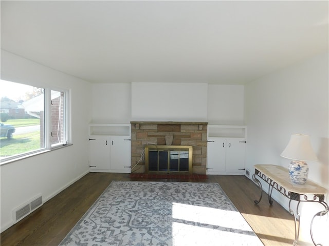 living room featuring dark wood-type flooring and a fireplace