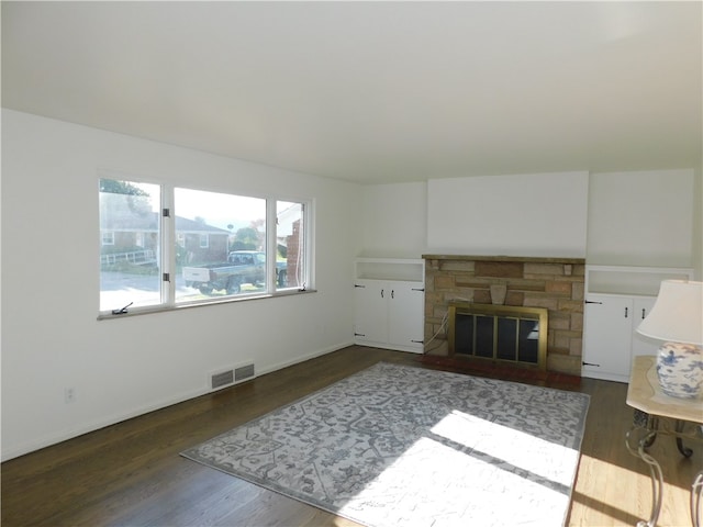 living room featuring dark wood-type flooring and a fireplace