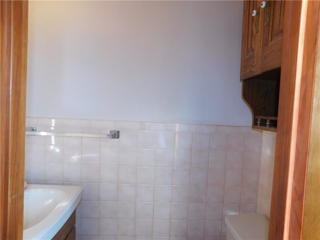 bathroom with vanity and tile walls