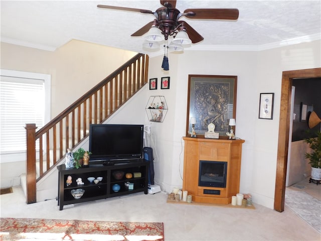 carpeted living room with crown molding, a textured ceiling, and ceiling fan