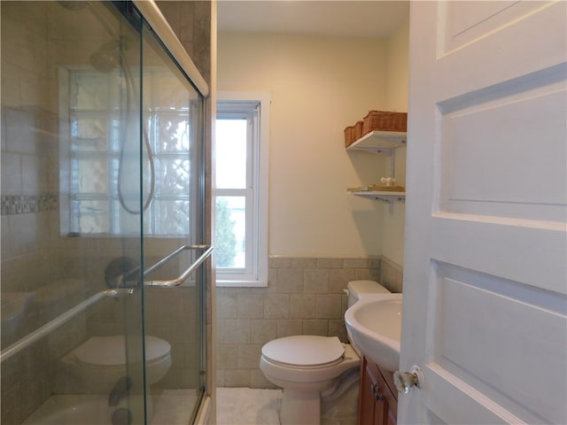 bathroom featuring vanity, an enclosed shower, toilet, and tile walls