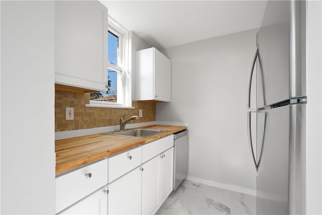 kitchen with tasteful backsplash, appliances with stainless steel finishes, and white cabinets