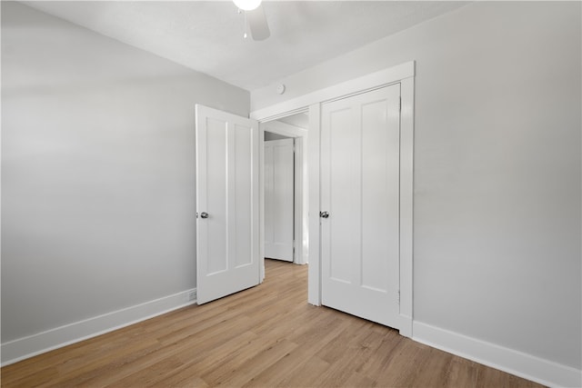 unfurnished bedroom with light hardwood / wood-style flooring, a closet, and ceiling fan