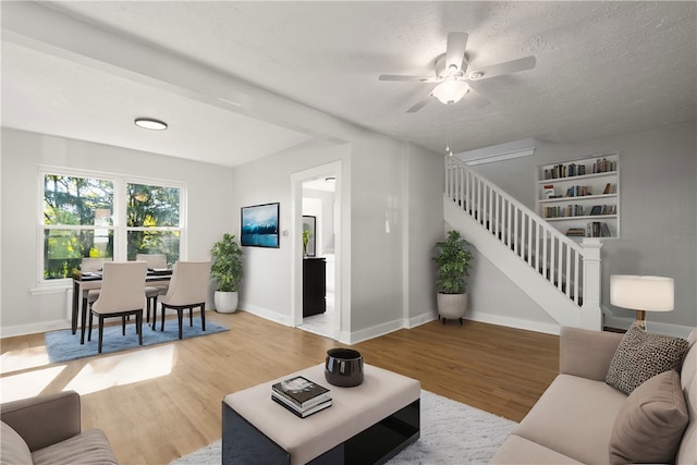 living room with a textured ceiling, hardwood / wood-style flooring, and ceiling fan