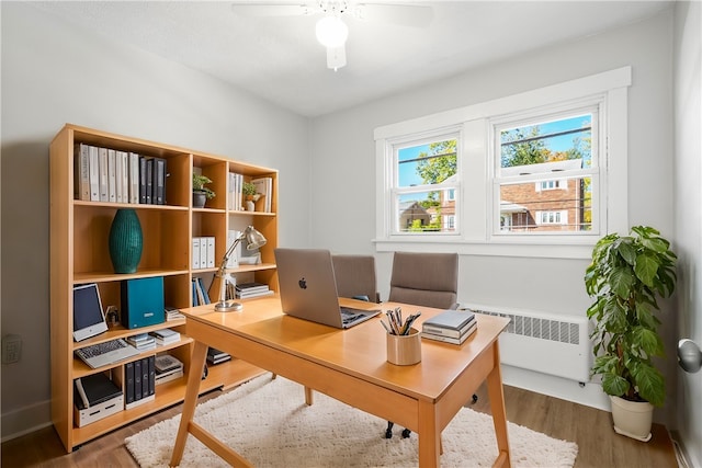 office featuring radiator, ceiling fan, and dark hardwood / wood-style floors