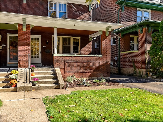 entrance to property with a yard and a porch