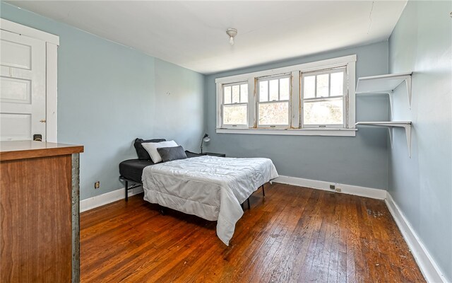 bedroom with dark wood-type flooring