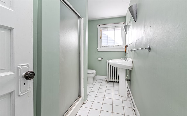 bathroom with tile patterned floors, a shower with shower door, and toilet