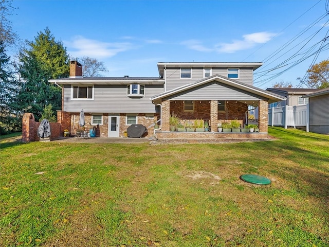 back of property featuring a patio area and a lawn