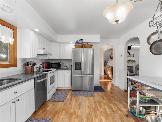 kitchen featuring white cabinetry, light hardwood / wood-style floors, appliances with stainless steel finishes, and pendant lighting