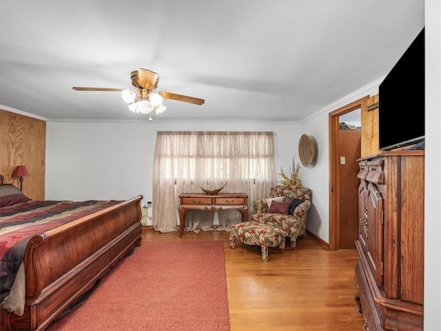 bedroom featuring ceiling fan, wood-type flooring, and ornamental molding