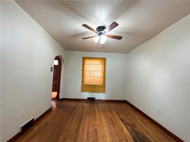 spare room featuring dark wood-type flooring and ceiling fan