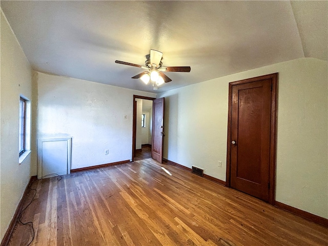 spare room featuring hardwood / wood-style floors, vaulted ceiling, and ceiling fan