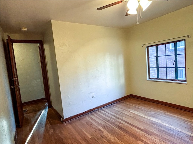 empty room with ceiling fan and dark hardwood / wood-style flooring