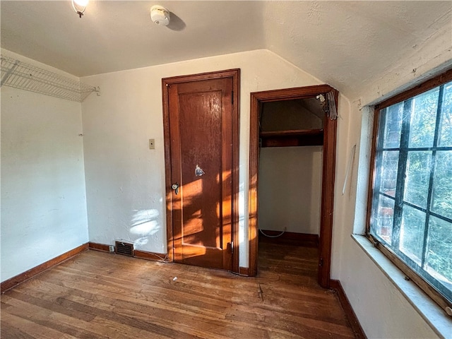 spare room with lofted ceiling and dark hardwood / wood-style floors