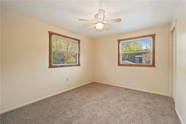 carpeted spare room with a wealth of natural light and ceiling fan