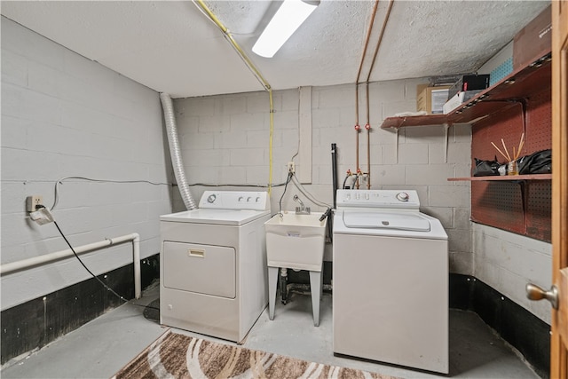 laundry room featuring sink, a textured ceiling, and separate washer and dryer