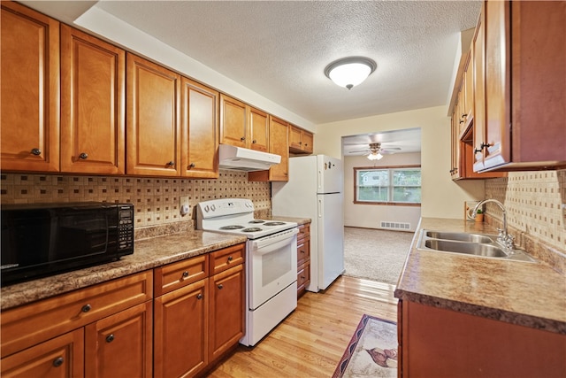 kitchen with white appliances, backsplash, and sink