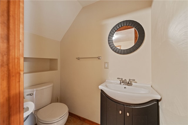 bathroom with vanity, toilet, and lofted ceiling