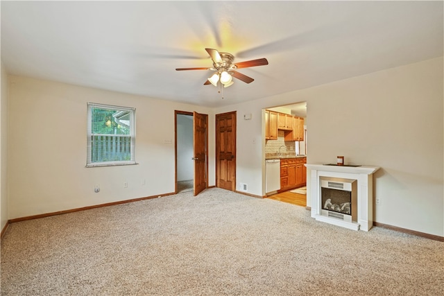 unfurnished living room with light carpet, sink, and ceiling fan