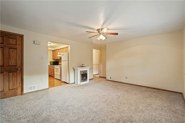 unfurnished living room with light carpet and ceiling fan