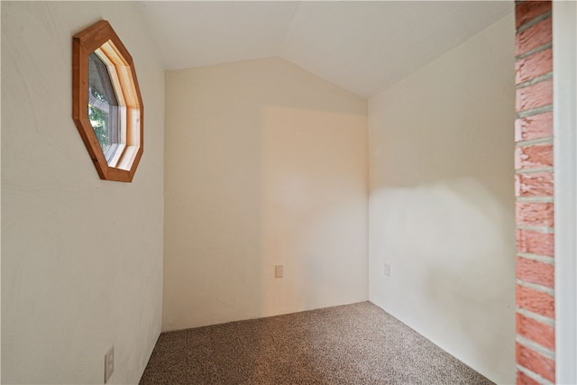 spare room featuring vaulted ceiling and carpet floors