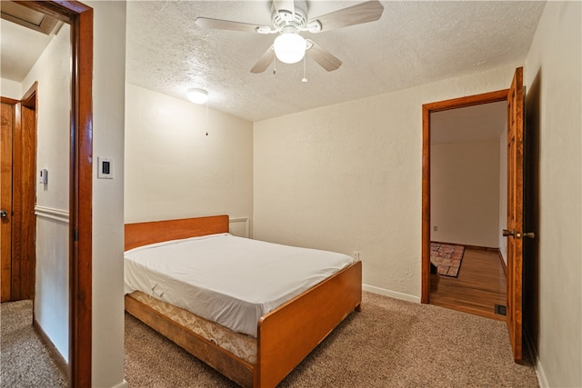 carpeted bedroom with a textured ceiling and ceiling fan