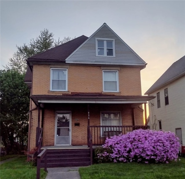 view of front facade with a porch and a lawn