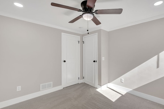 carpeted spare room featuring crown molding and ceiling fan