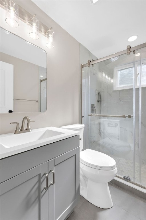 bathroom with vanity, a shower with shower door, toilet, and tile patterned flooring