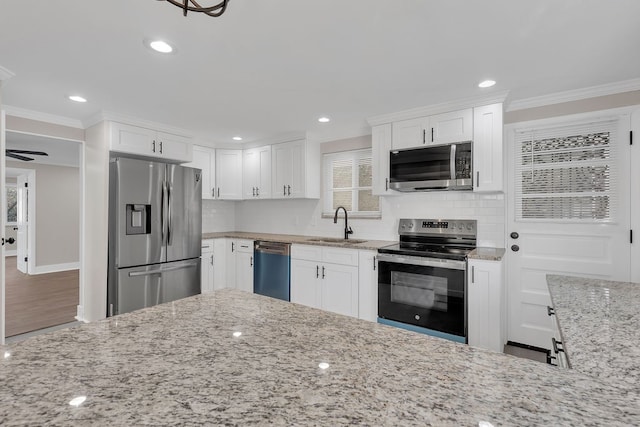 kitchen with white cabinetry, hardwood / wood-style flooring, stainless steel appliances, and ornamental molding