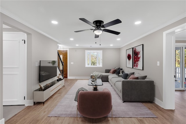 living room with crown molding, a wealth of natural light, and light wood-type flooring