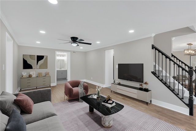 living room featuring crown molding, light hardwood / wood-style flooring, and ceiling fan with notable chandelier